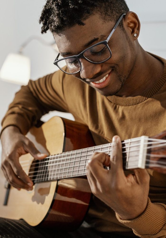 front-view-smiley-male-musician-home-playing-guitar-bed-scaled-quxl0o963wgsiwebad0iknhol1w54myes3m6z8w3rk